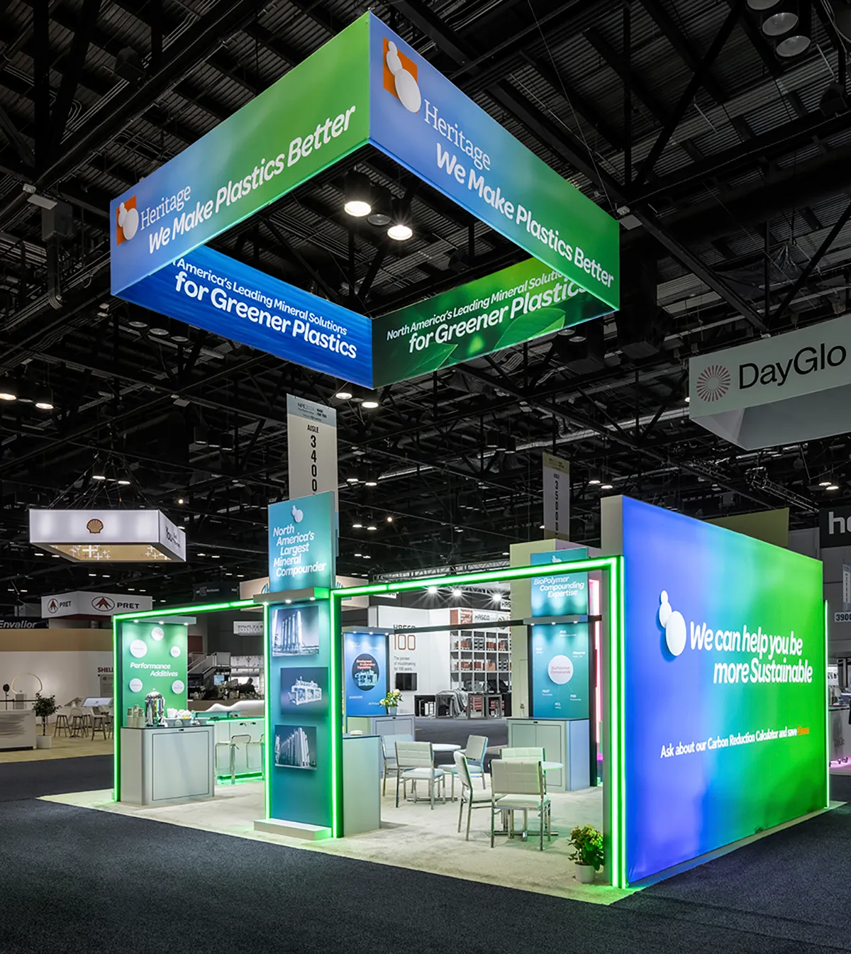 Corner view of the Heritage Plastics booth with backlit graphics and work counters
