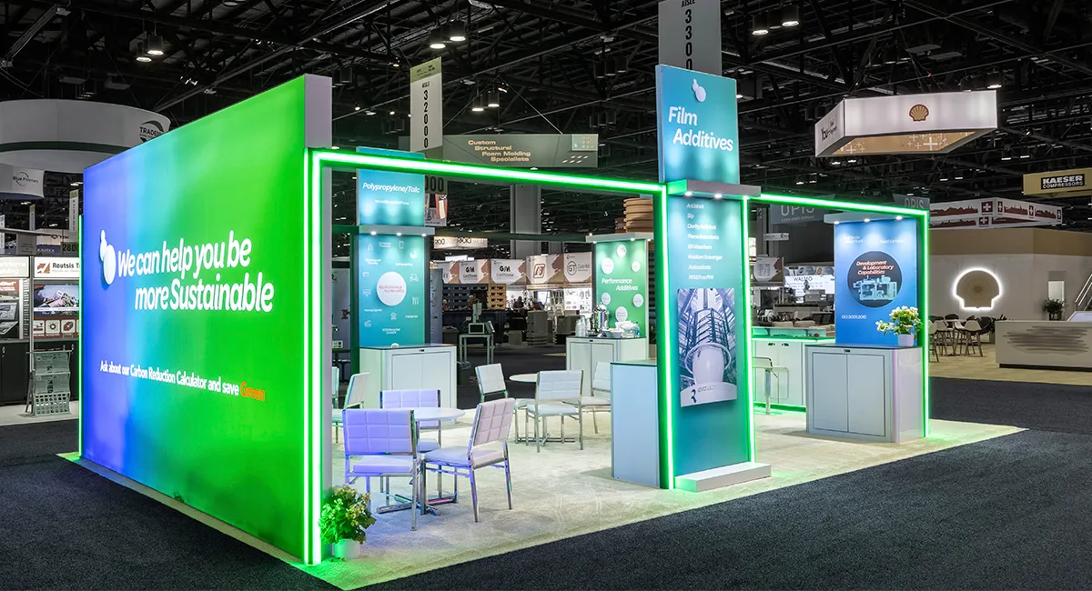 Heritage Plastics exhibit at NPE 2024 with green and blue backlit walls
