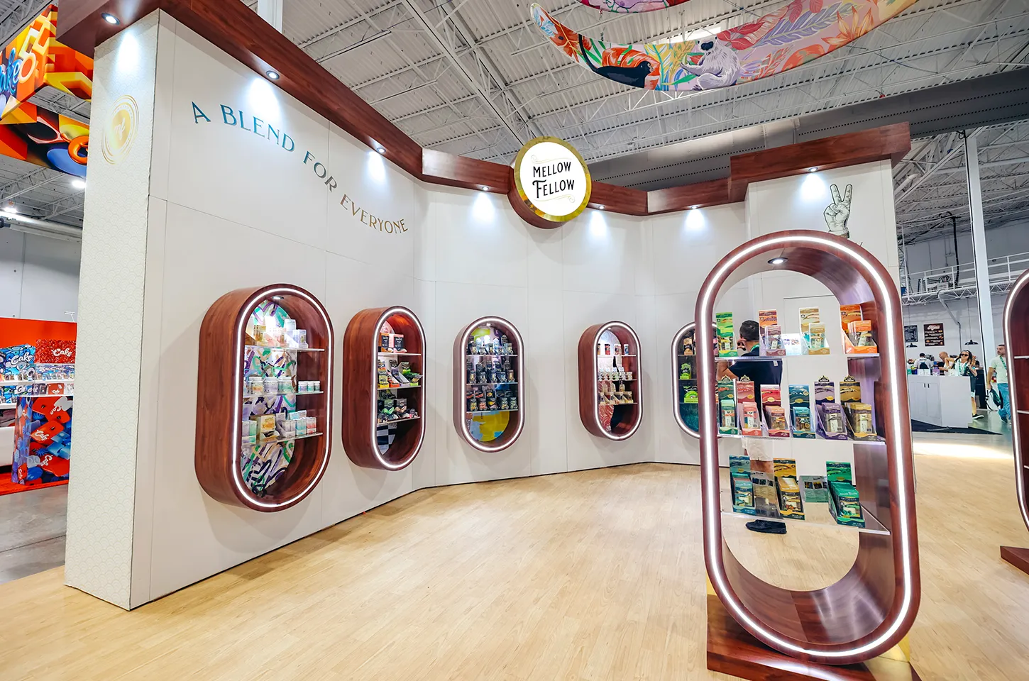 Mellow Fellow exhibit with walnut-framed oval product niches and a curved white wall