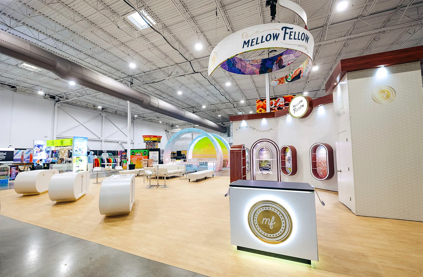 Mellow Fellow exhibit by Exhibit Craft with a hanging ring sign and white lounge seating