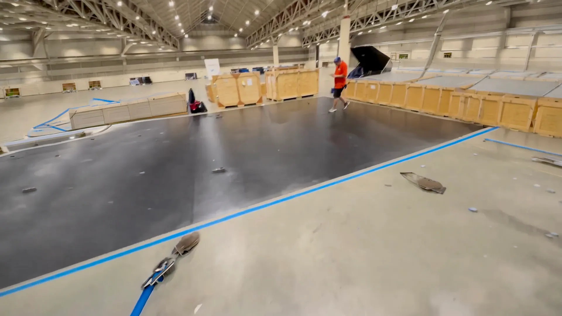 Crew marking out a booth space on an empty convention hall floor